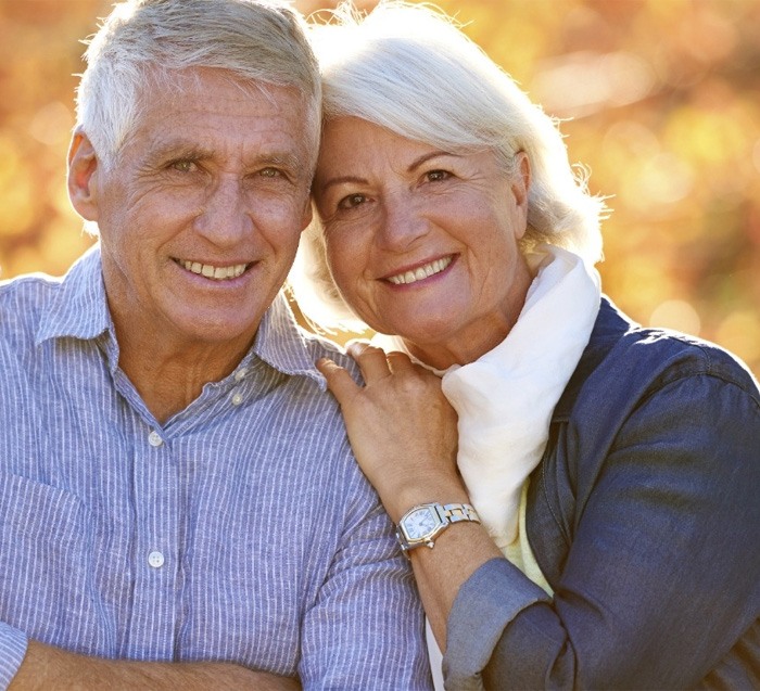 Man and woman enjoying the benefits of dental implants